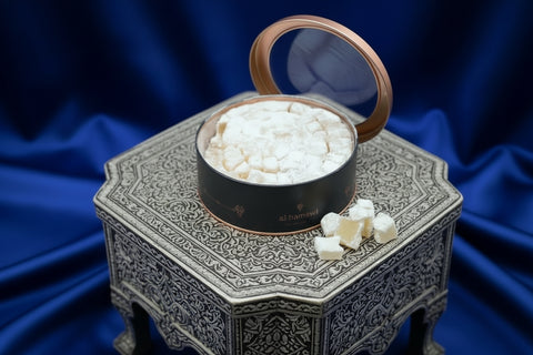 White crumbly substance in a black container on a blue background